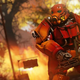 A person in a red-colored set of power armor prepares to fire a gatling gun in a screenshot from Fallout 76.